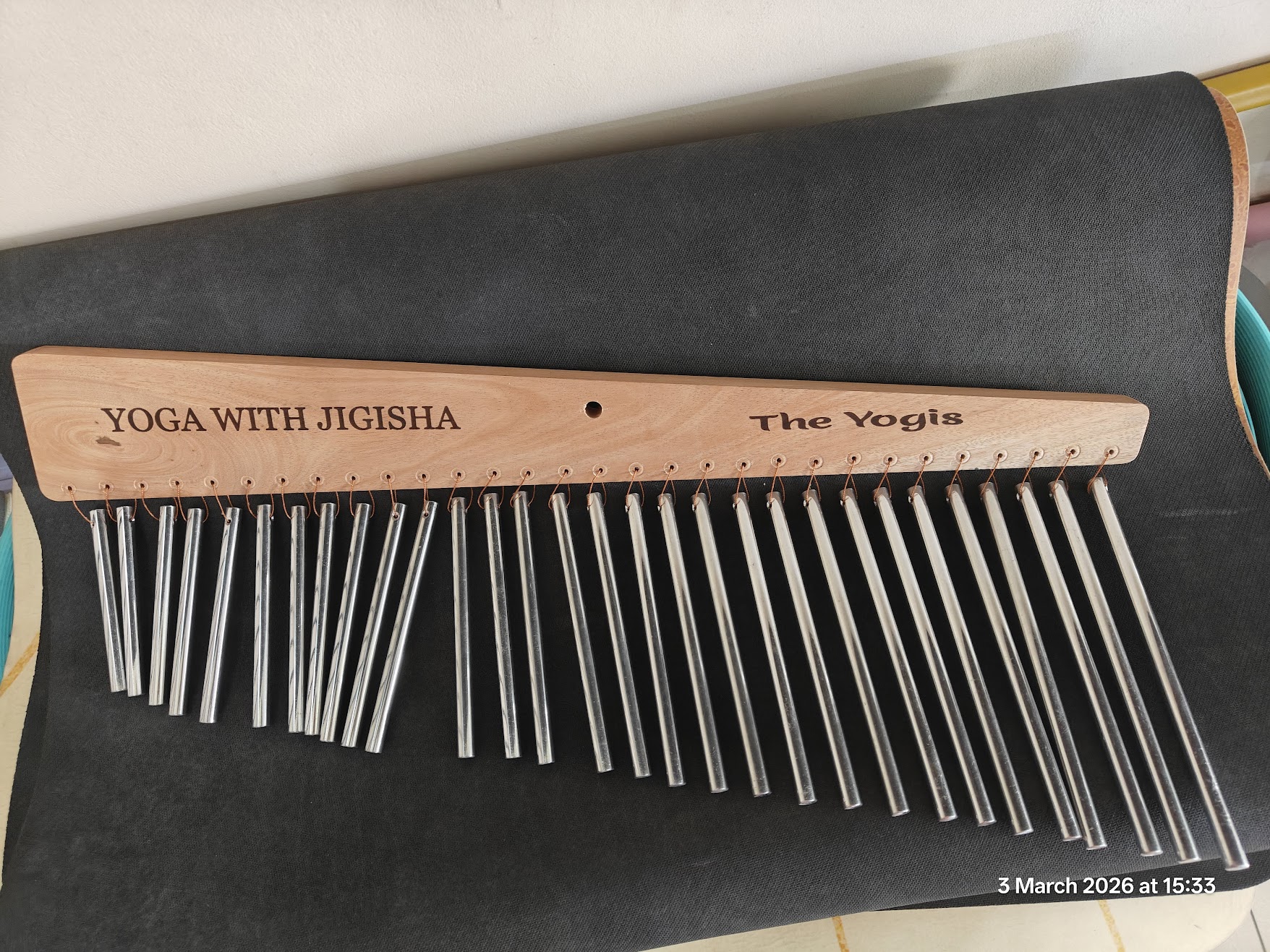 Yoga With Jigisha customized 27-chime sound healing instrument with engraved 'The Yogis' branding on wooden bar, used in meditation and pranayama sessions in Bangalore March 2026