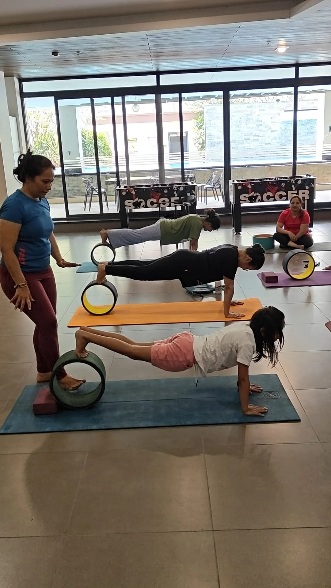 Plank on Yoga Wheel - Group wheel yoga class with students in plank pose on wheels at Yoga With Jigisha March 2026