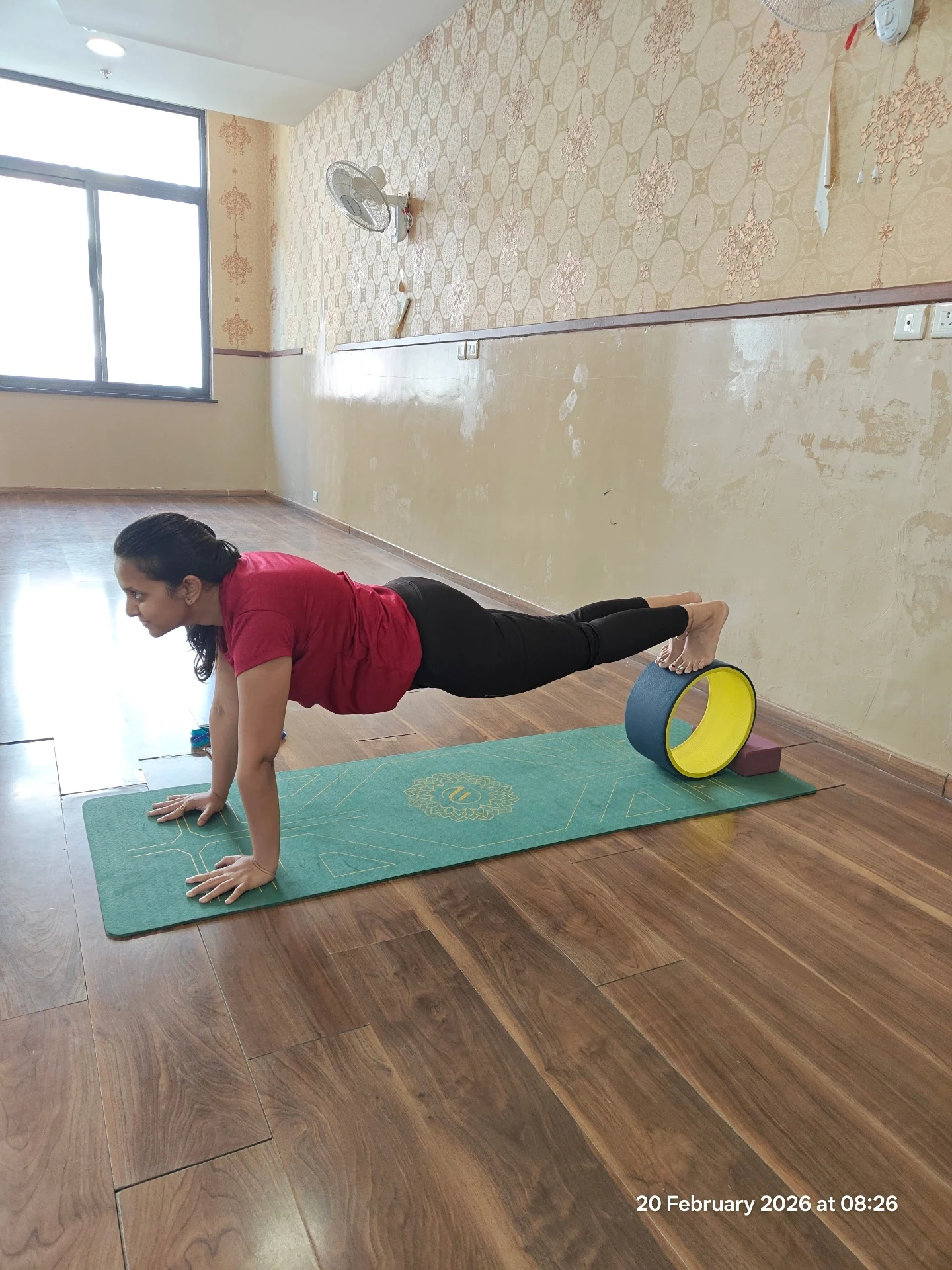 Wheel Yoga Plank Balance - Student performing plank with feet on yoga wheel at Yoga With Jigisha studio