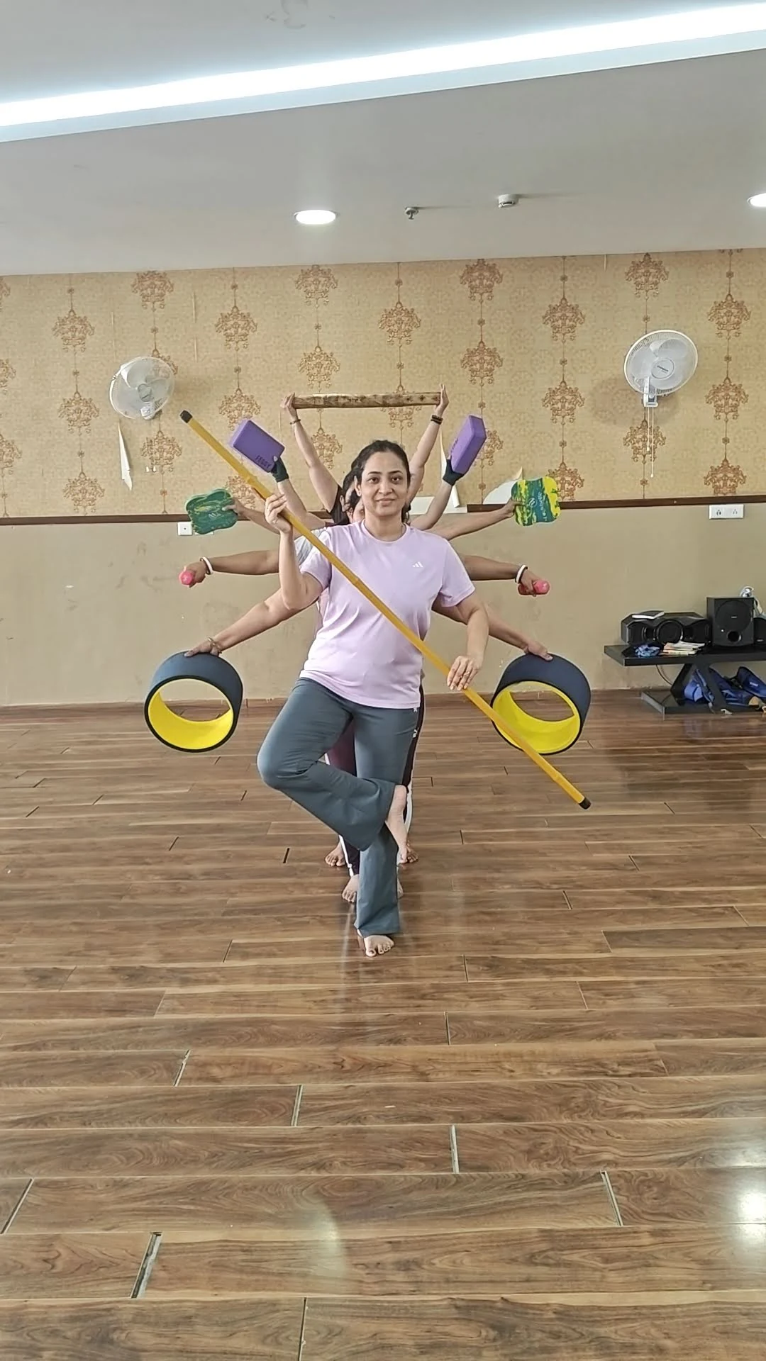 Creative Yoga with Props - Student in tree pose with yoga wheel, stick, blocks and dumbbells at Yoga With Jigisha