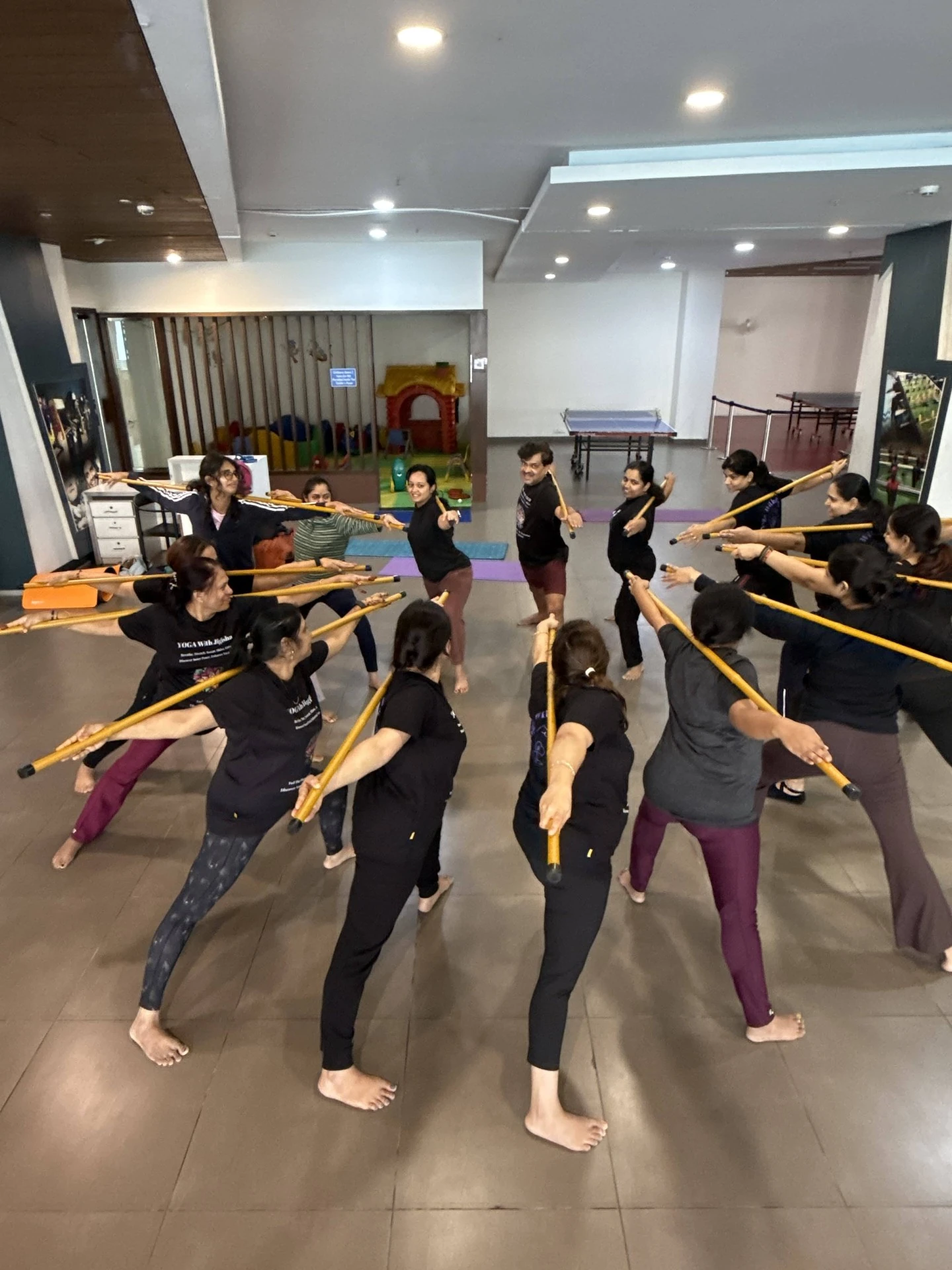 Group Stick Yoga Formation - Students in synchronized stick yoga poses demonstrating proper alignment